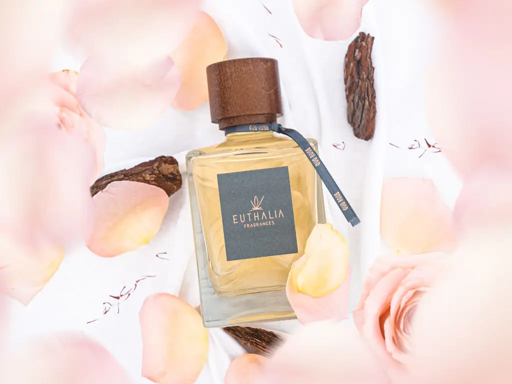 Profumo ambiente di lusso Oud Rose di Euthalia Fragrances, circondato da petali di rosa e legno di oud, ideale per ambienti raffinati. Benessere. Wellness.