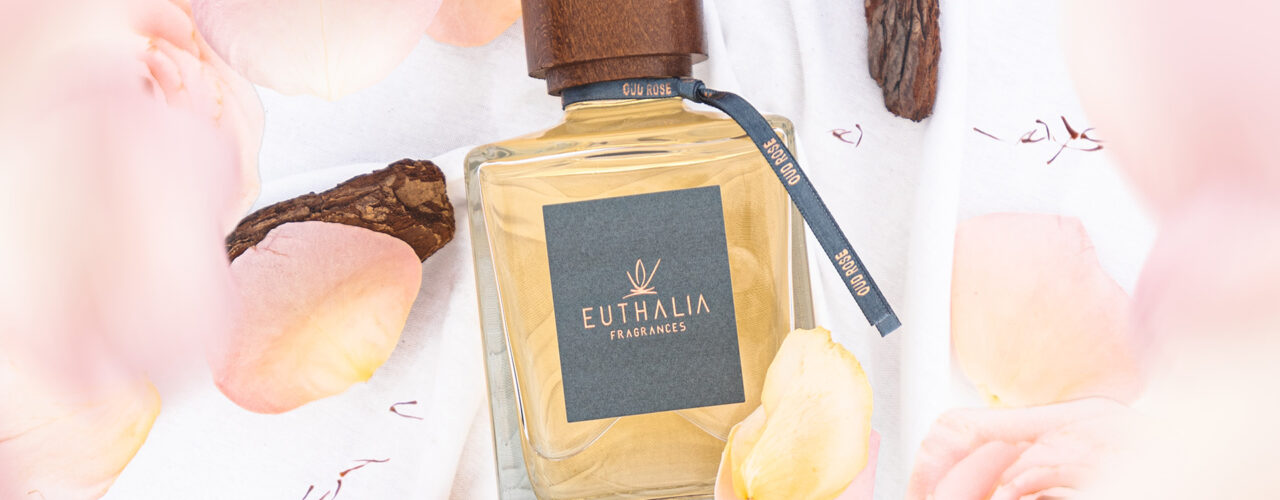 Profumo di lusso Oud Rose di Euthalia Fragrances, circondato da petali di rosa e legno di oud, ideale per ambienti raffinati. Benessere. Wellness.