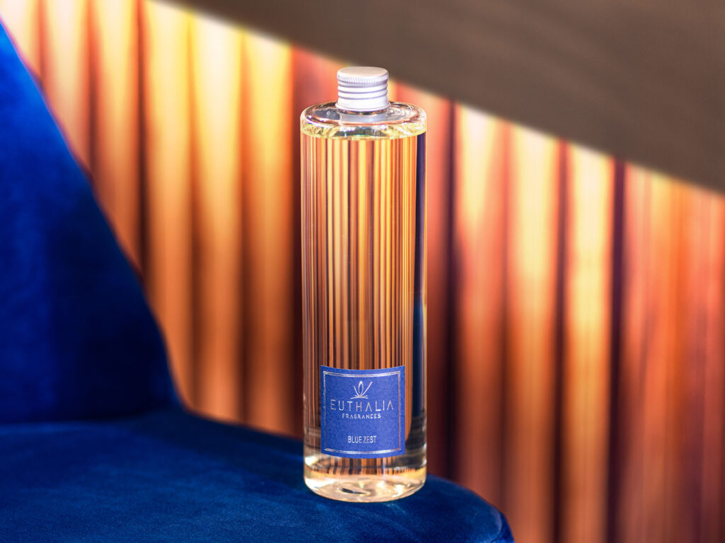 Refill di fragranze Euthalia Blue Zest in una bottiglia elegante, posizionata su uno sfondo caldo e avvolgente. Perfetta per chi desidera un profumo ambientale di qualità con un tocco di freschezza agrumata.